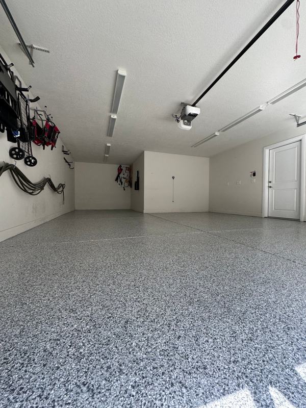 Low angle view of a blue gray flake garage floor and wall mounted tools