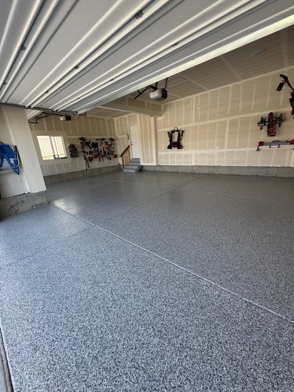 Blue gray flake floor running from the driveway into a two car garage