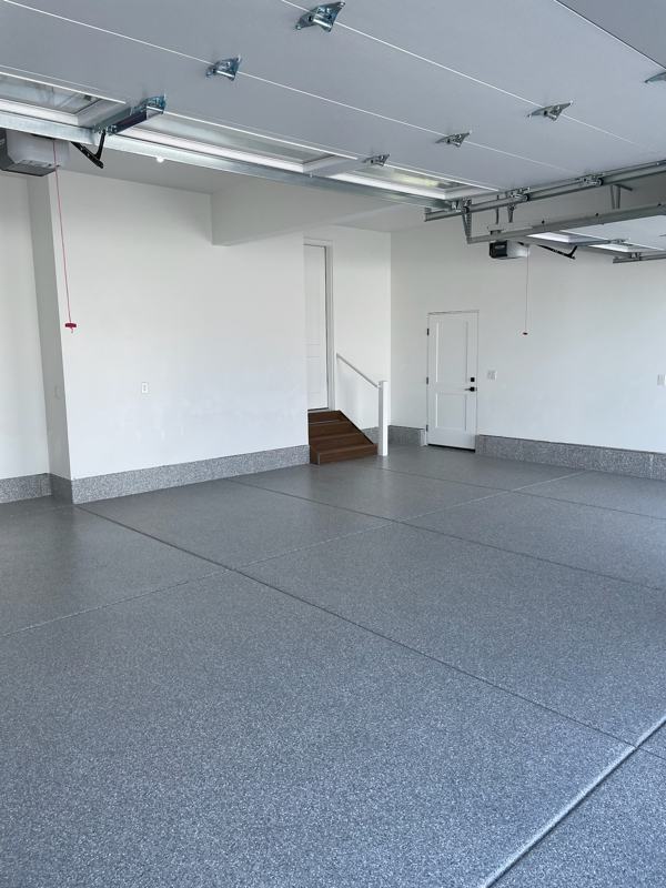 Three car garage with a gray flake floor and white walls