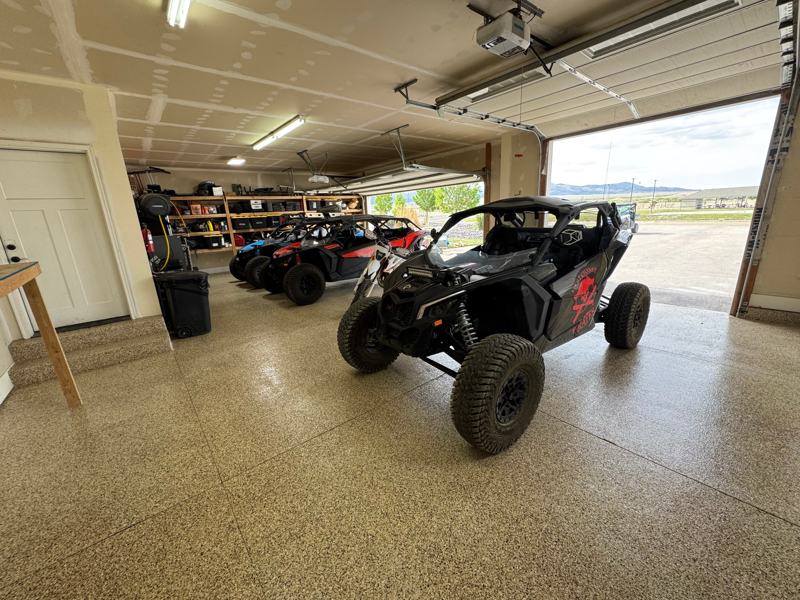 Tan flake garage floor holding three side by side off road vehicles