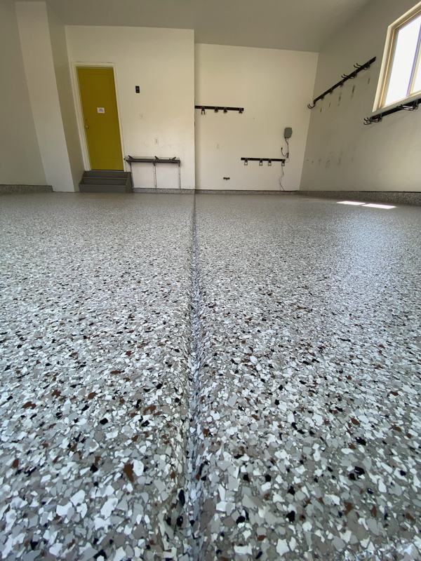 Close up of flake floor with a control joint running to a yellow door